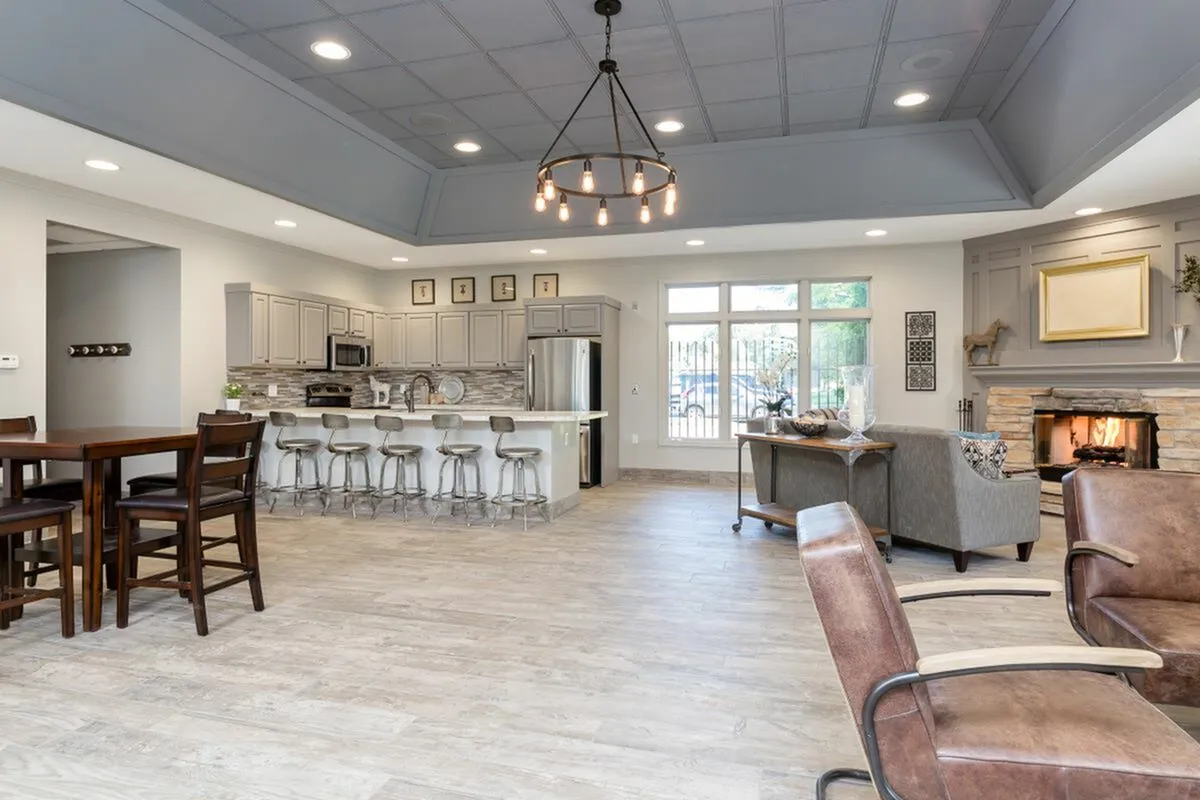Inviting open-concept living space featuring a modern kitchen with a large island, stylish dining area, and cozy lounge with a fireplace.