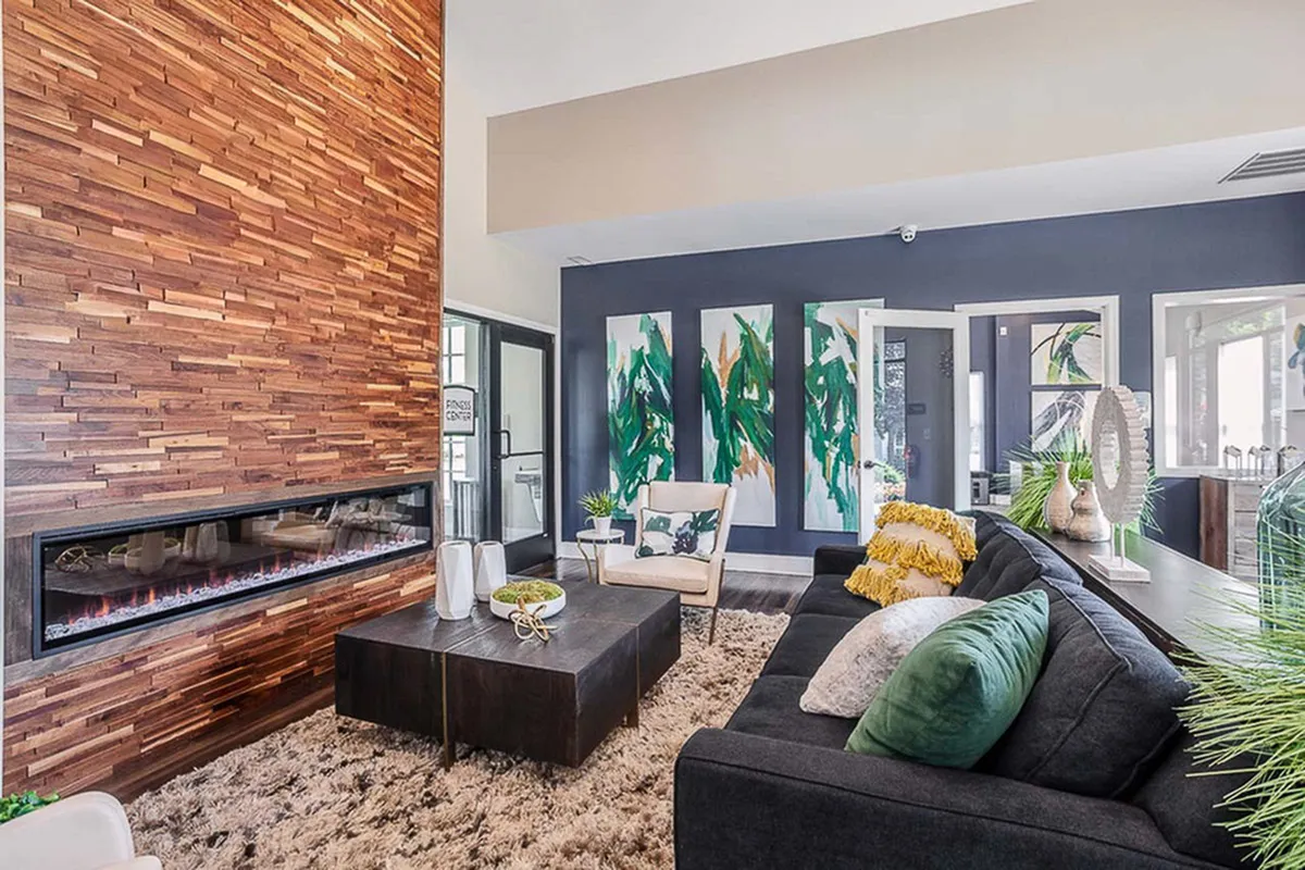 Chic and modern living room with a stylish wooden accent wall and sleek fireplace, complemented by a plush couch and vibrant abstract artwork.
