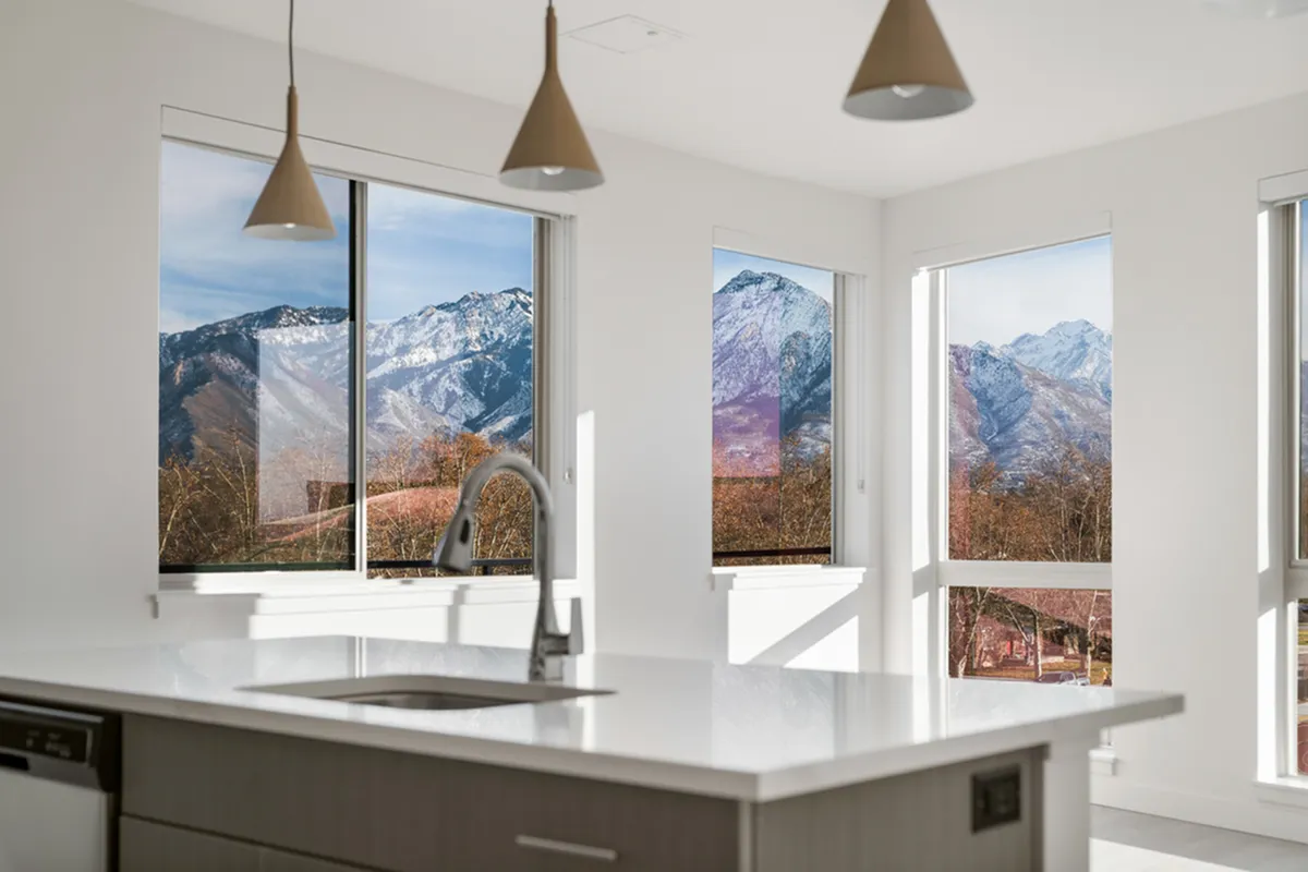 Sleek kitchen with mountain views through large windows, featuring modern fixtures and abundant natural light.