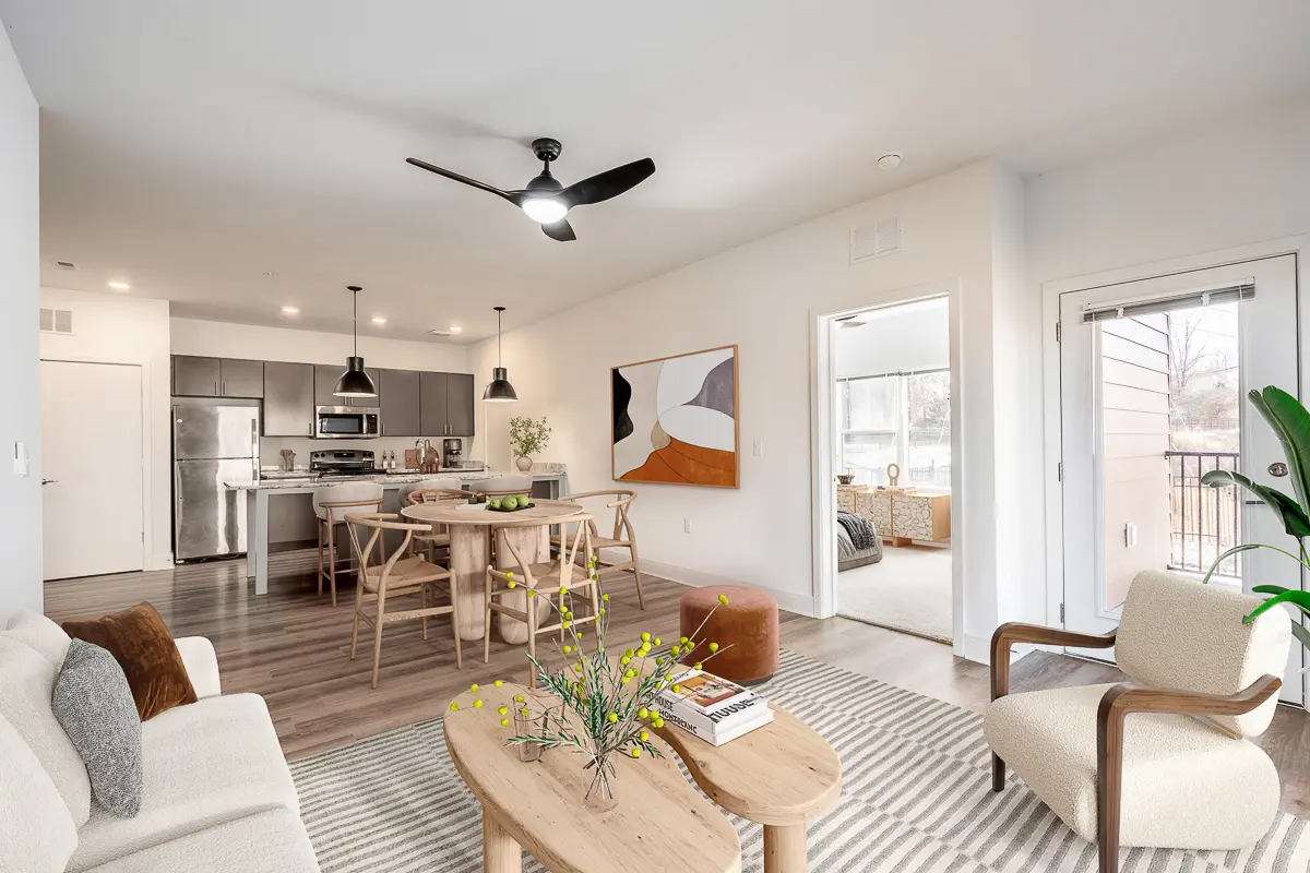 Modern open-concept living area with sleek kitchen, stylish dining space, and cozy seating in a bright and inviting apartment.