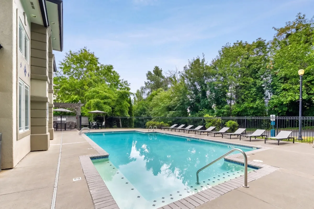 Inviting outdoor swimming pool surrounded by elegant lounge chairs and lush greenery.