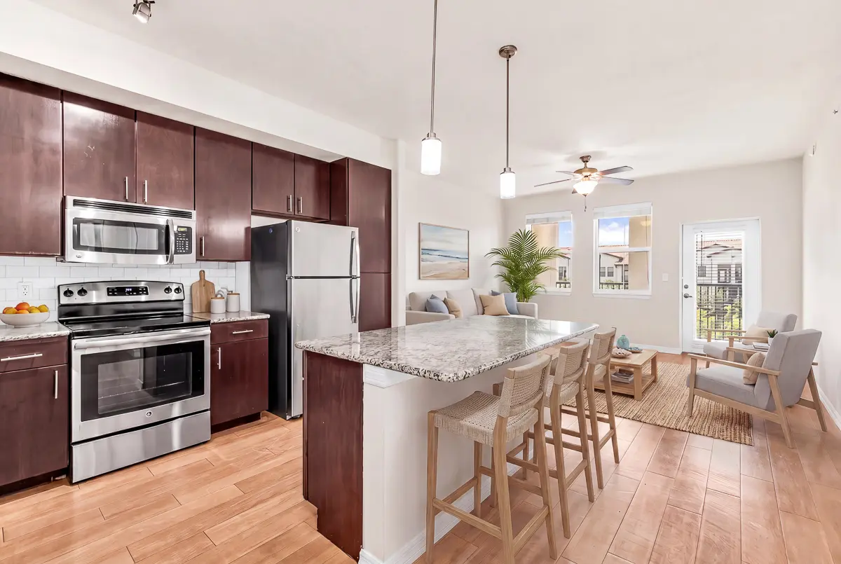 Contemporary kitchen at Cottonwood Lighthouse Point with sleek stainless steel appliances, rich dark wood cabinetry, and elegant granite countertops.