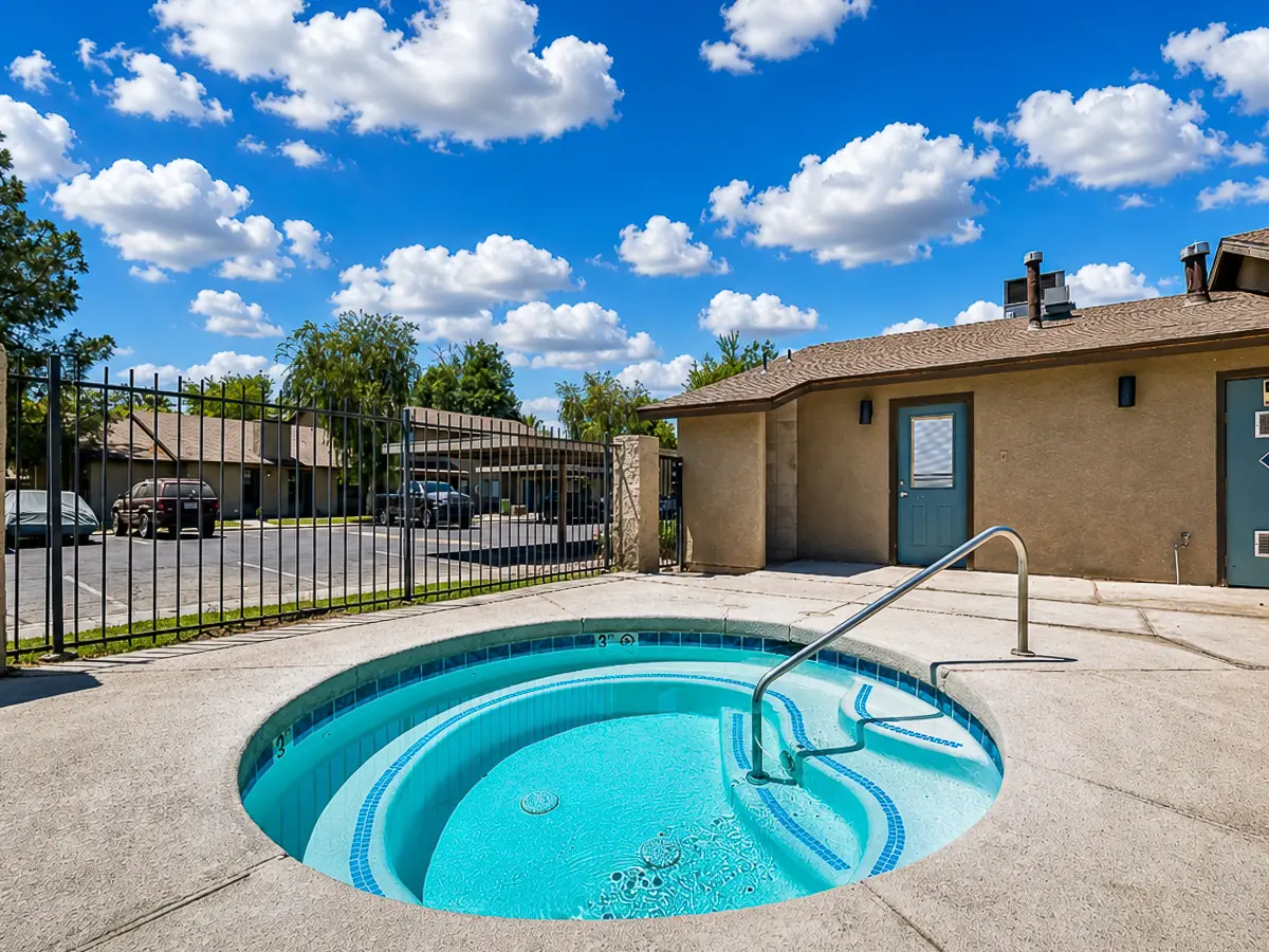 Inviting outdoor jacuzzi area under a vibrant blue sky, perfect for relaxation and enjoyment in a serene apartment community at Camelot Apartments in Yuma, AZ.