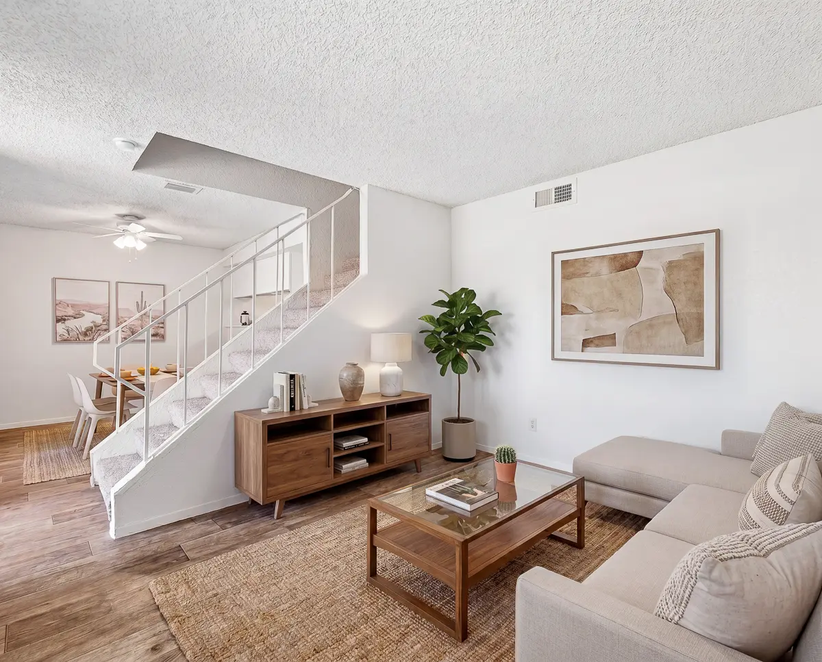 Inviting open-plan living area with cozy sofa, stylish armchair, and sleek modern kitchen, perfect for relaxation and entertaining.