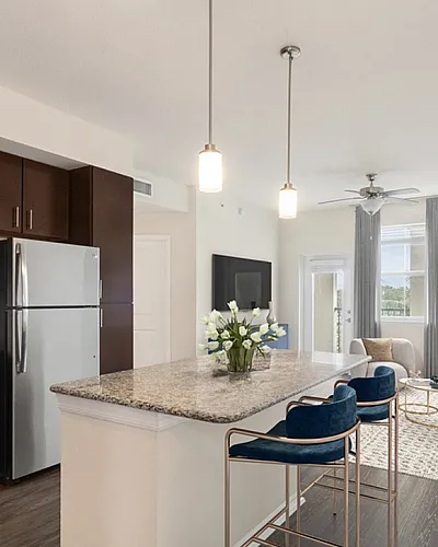 Elegant open-concept kitchen and living room at Cottonwood Lighthouse Point with modern appliances, sleek granite countertops, and inviting natural light.