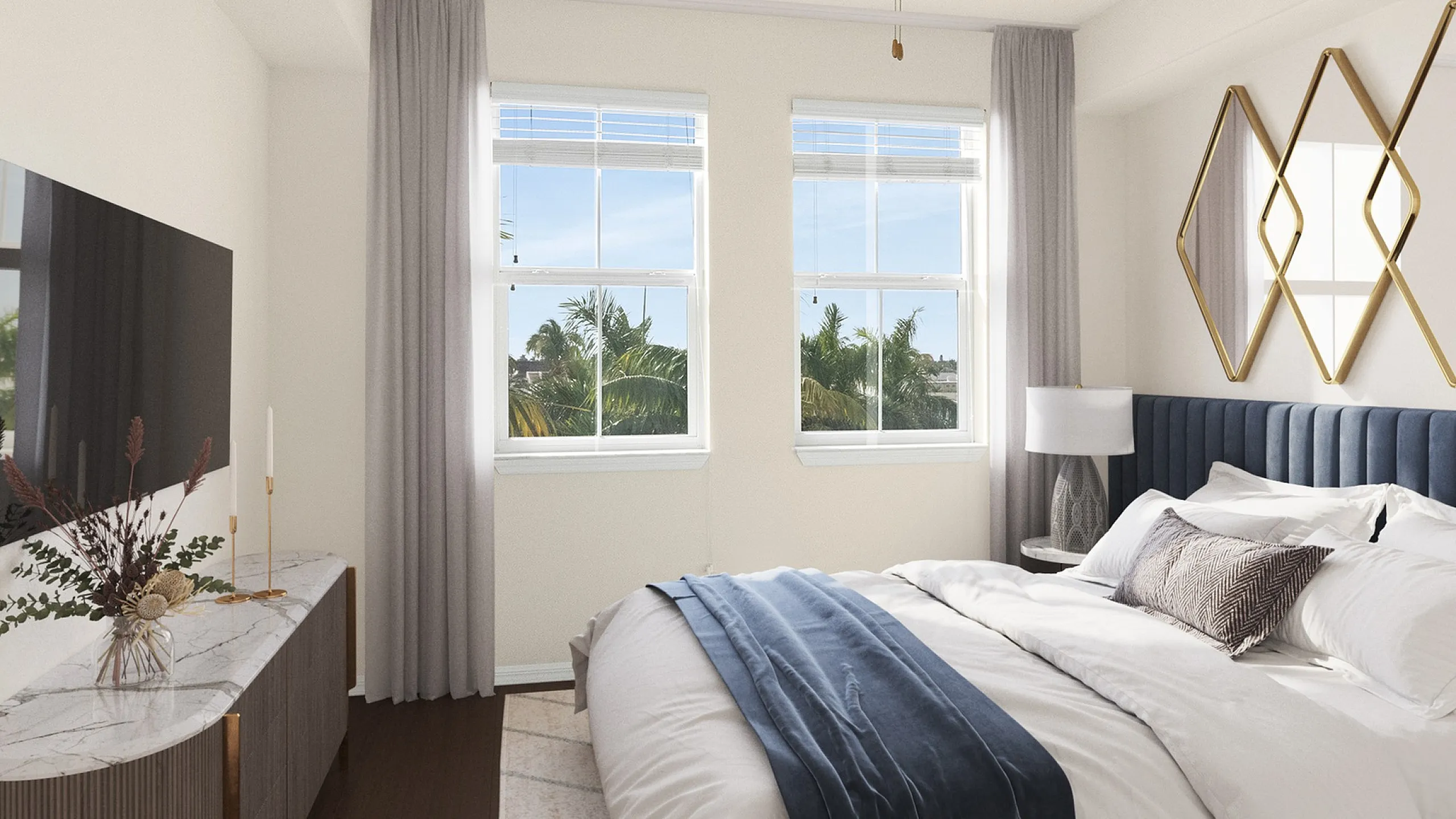 Elegant bedroom with plush navy headboard, large windows allowing natural light, and sophisticated decor for a serene retreat at Cottonwood Lighthouse Point in Pompano Beach