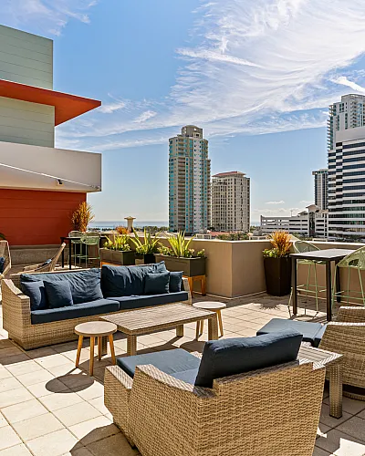 Luxurious rooftop patio with stylish seating, modern architecture, and stunning city skyline views of downtown St. Pete