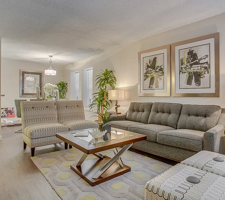Inviting living room at Regatta Apartments with elegant decor, featuring plush seating, vibrant artwork, and abundant natural light.