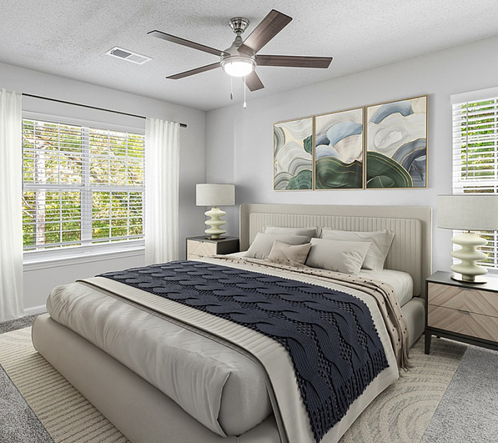 Inviting bedroom with a large cozy bed, elegant decor, and abundant natural light from two windows.