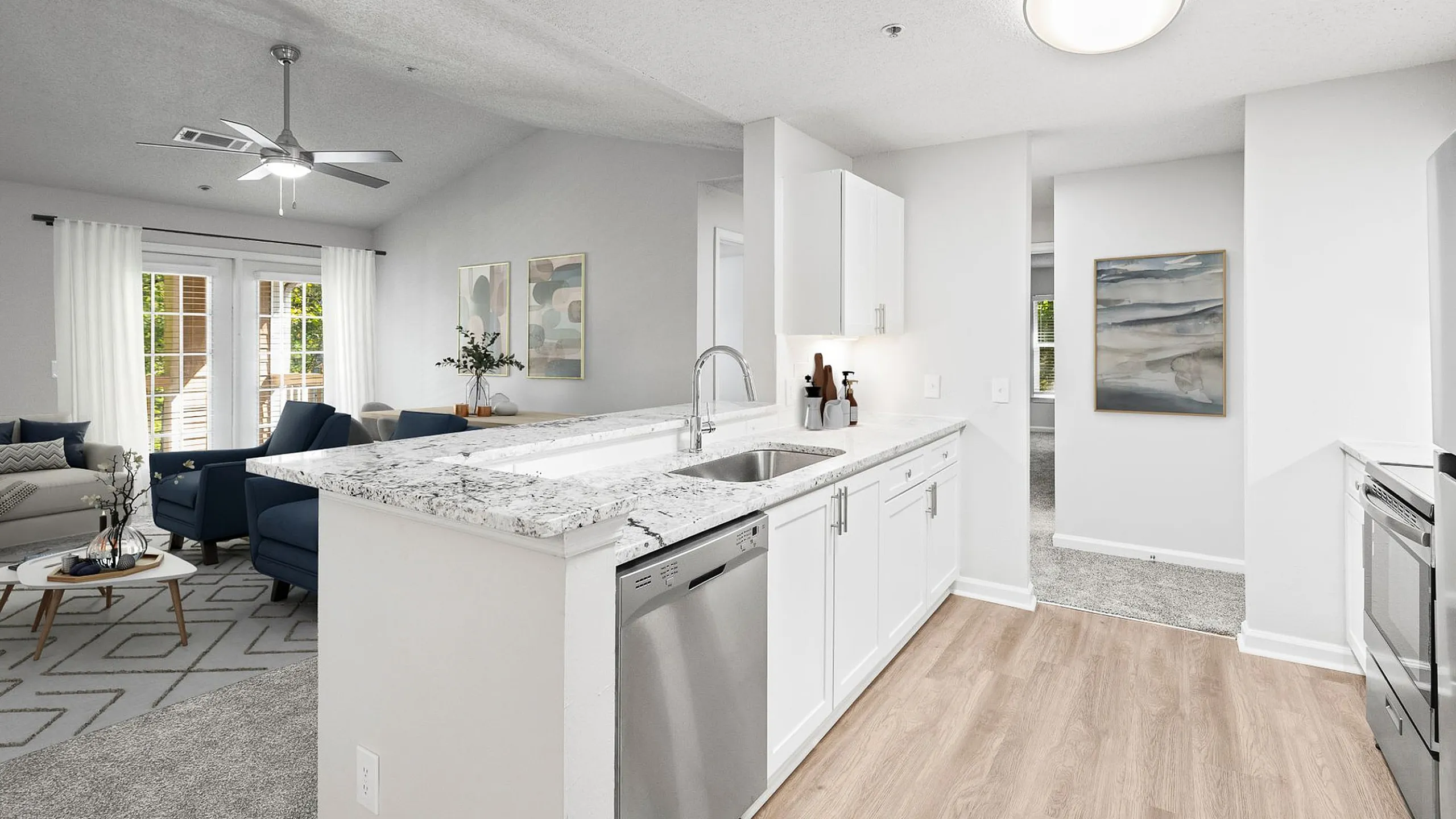 Bright and modern open-concept kitchen and living room with sleek granite countertops, stainless steel appliances, and cozy sitting area with elegant d&eacute;cor.