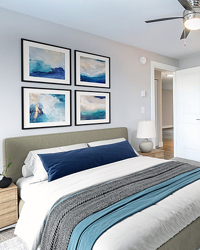 Elegant bedroom with plush carpeting, modern ceiling fan, and stylish artwork, complemented by a cozy bed and chic nightstands.
