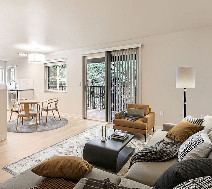 Contemporary open living area with elegant seating, natural light, and access to a private balcony.
