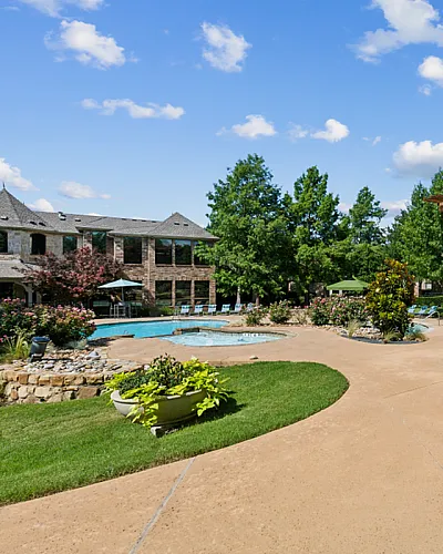 Charming outdoor area featuring a luxurious pool, elegant pergola dining space, and lush greenery under a vibrant blue sky Enclave at Golden Triangle in Fort Worth TX