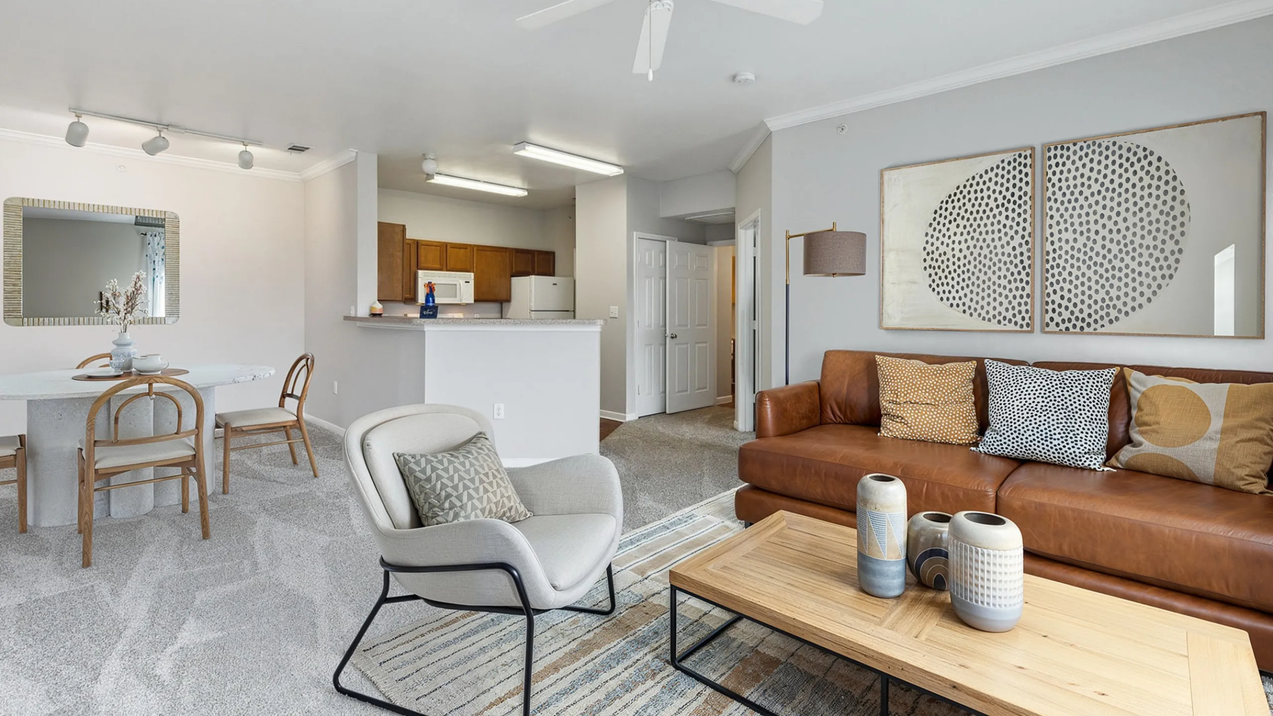 Inviting open-plan living room with stylish decor, elegant leather sofa, and modern kitchen bar area.