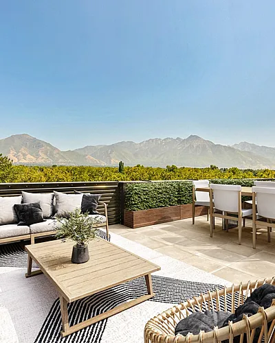 Stylish outdoor terrace with cozy lounge area and stunning mountain views, perfect for relaxation and entertaining at Cottonwood Highland in Millcreek Utah