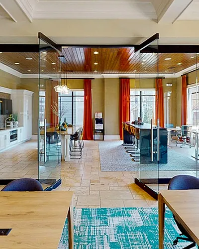 Elegant coworking space with a modern glass conference room, vibrant orange curtains, and stylish furnishings at Heights at Meridian in Durham NC