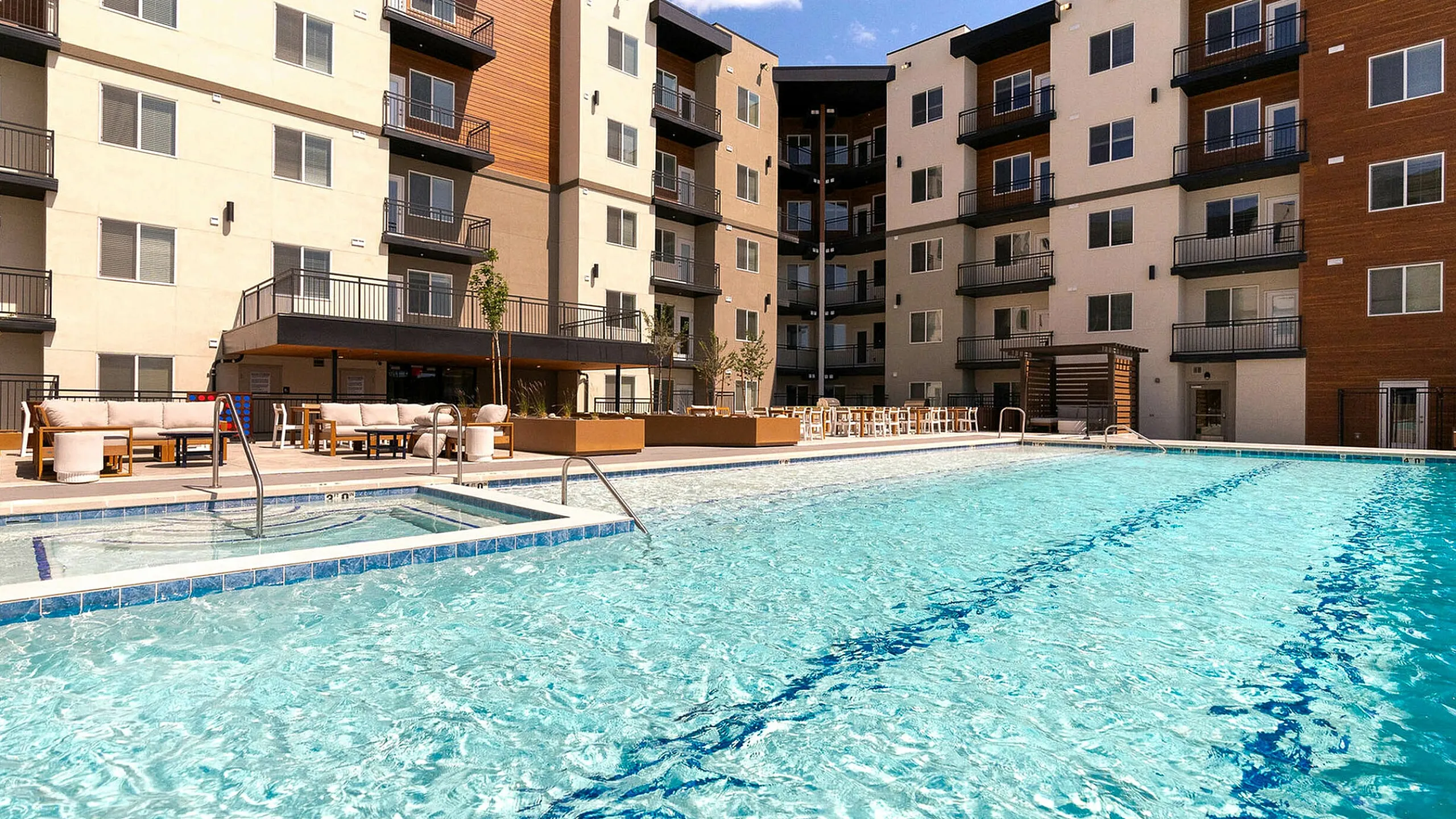 Luxurious apartment complex in the heart of Murray Utah featuring a sparkling outdoor swimming pool, modern design, and spacious balconies.