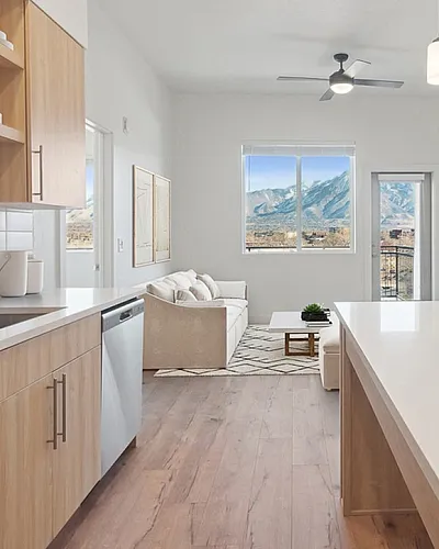 Modern open-concept kitchen and living area with elegant fixtures, light wood cabinetry, and breathtaking mountain views.