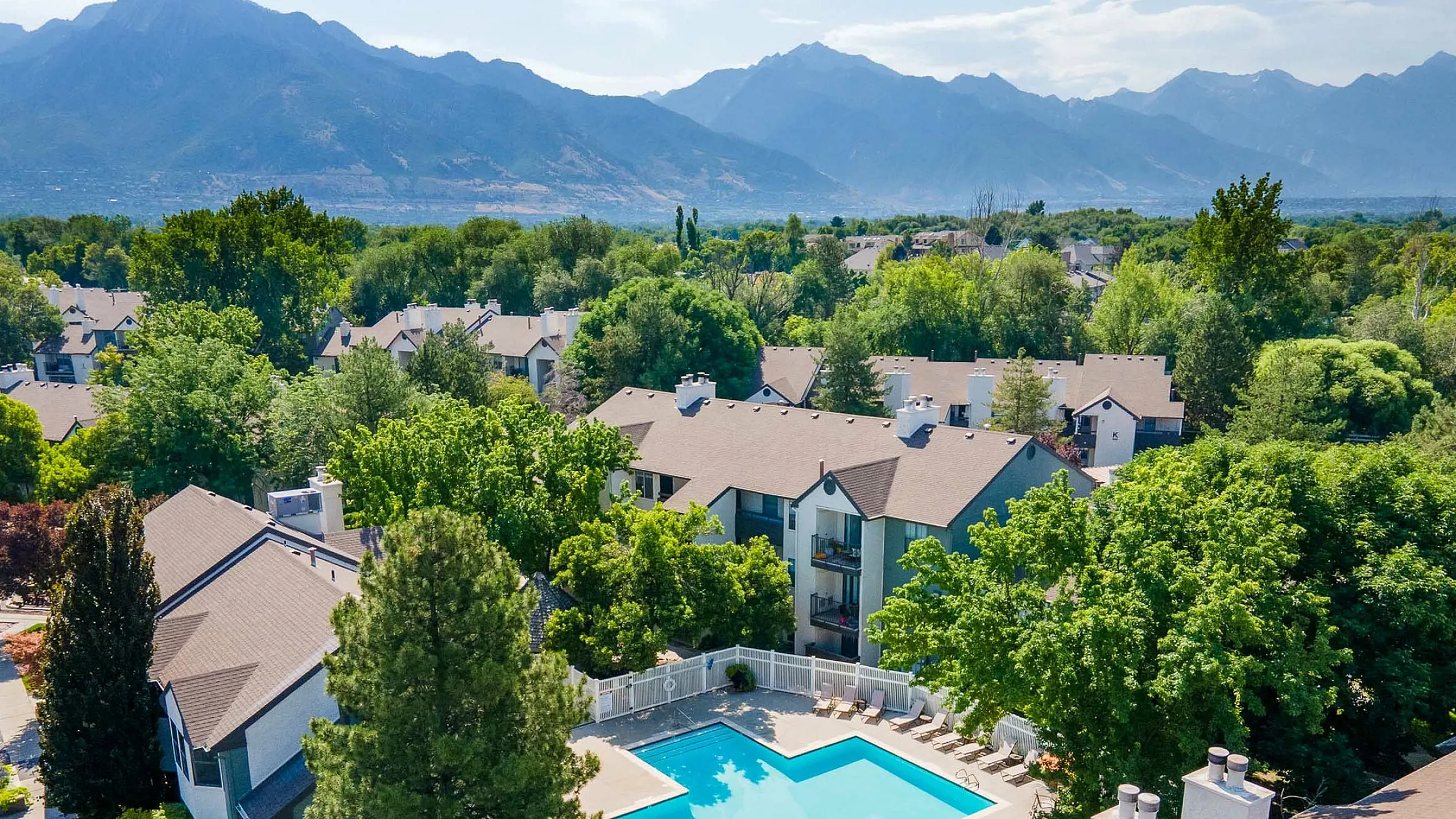 Charming residential community with lush greenery, sparkling pool, and stunning mountain views, offering a serene lifestyle.