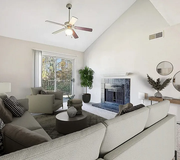 Elegant living room featuring vaulted ceiling, modern fireplace, and plush seating with scenic balcony views.
