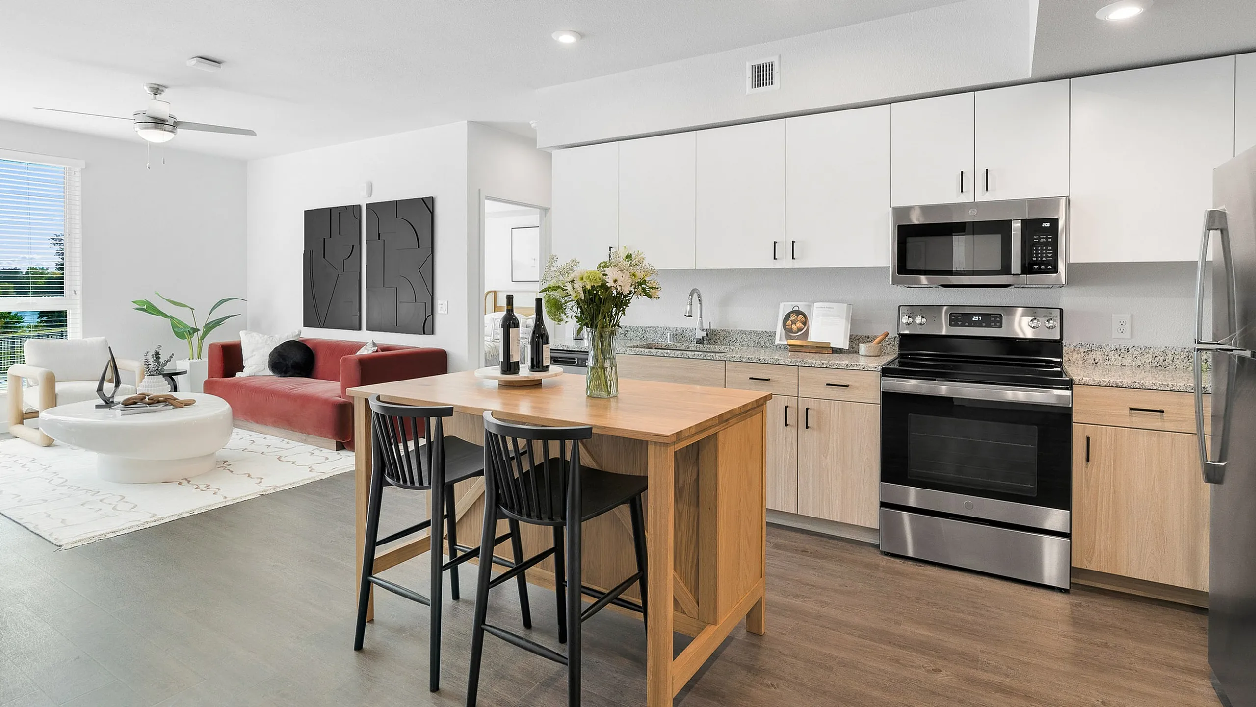 Contemporary open-plan living space featuring a stylish kitchen with stainless steel appliances, a chic dining area, and a cozy living room with modern decor.
