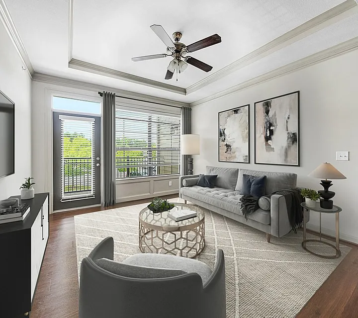 Bright and modern living room with chic decor, featuring a cozy sofa, elegant artwork, and a large window offering scenic views.