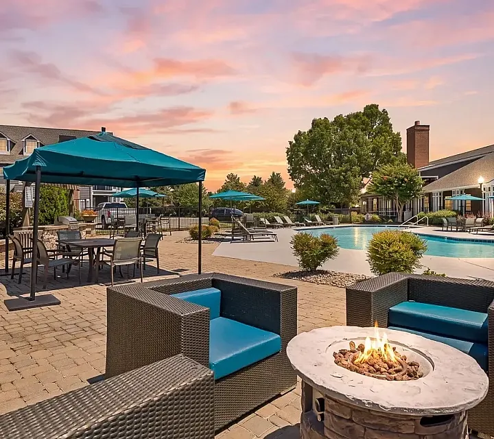 Luxurious poolside retreat with cozy fire pit, elegant seating, and vibrant sunset backdrop for ultimate relaxation.