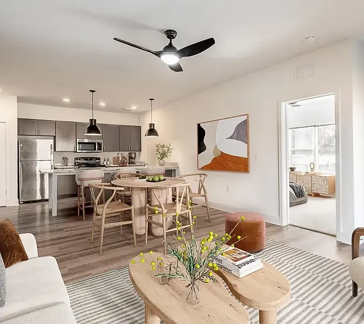 Modern open-plan kitchen and living room with stylish lighting, granite countertop island, and comfortable seating, leading to a bright and airy living space.