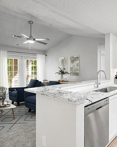 Elegant open-concept living area featuring a modern kitchen with a sleek marble countertop, integrated appliances, and cozy seating.