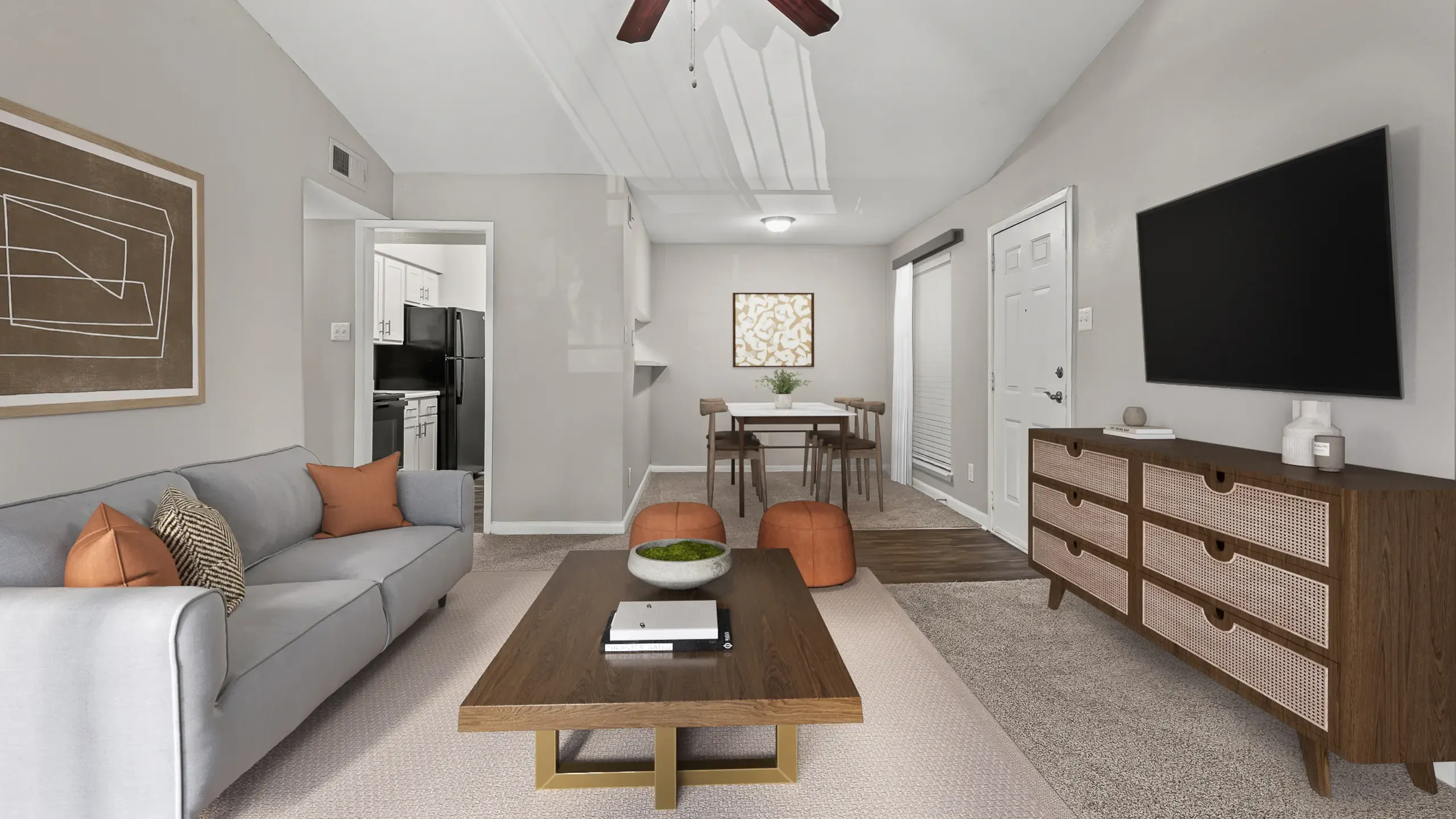 Modern living and dining area featuring a cozy gray sofa, elegant wooden coffee table, and sleek entertainment unit, flowing into a stylish dining space with contemporary chairs at Autumn Ridge Apartments