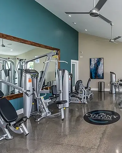 Stylish apartment complex featuring a sparkling outdoor pool with vibrant orange loungers and umbrellas, surrounded by lush greenery and modern amenities.