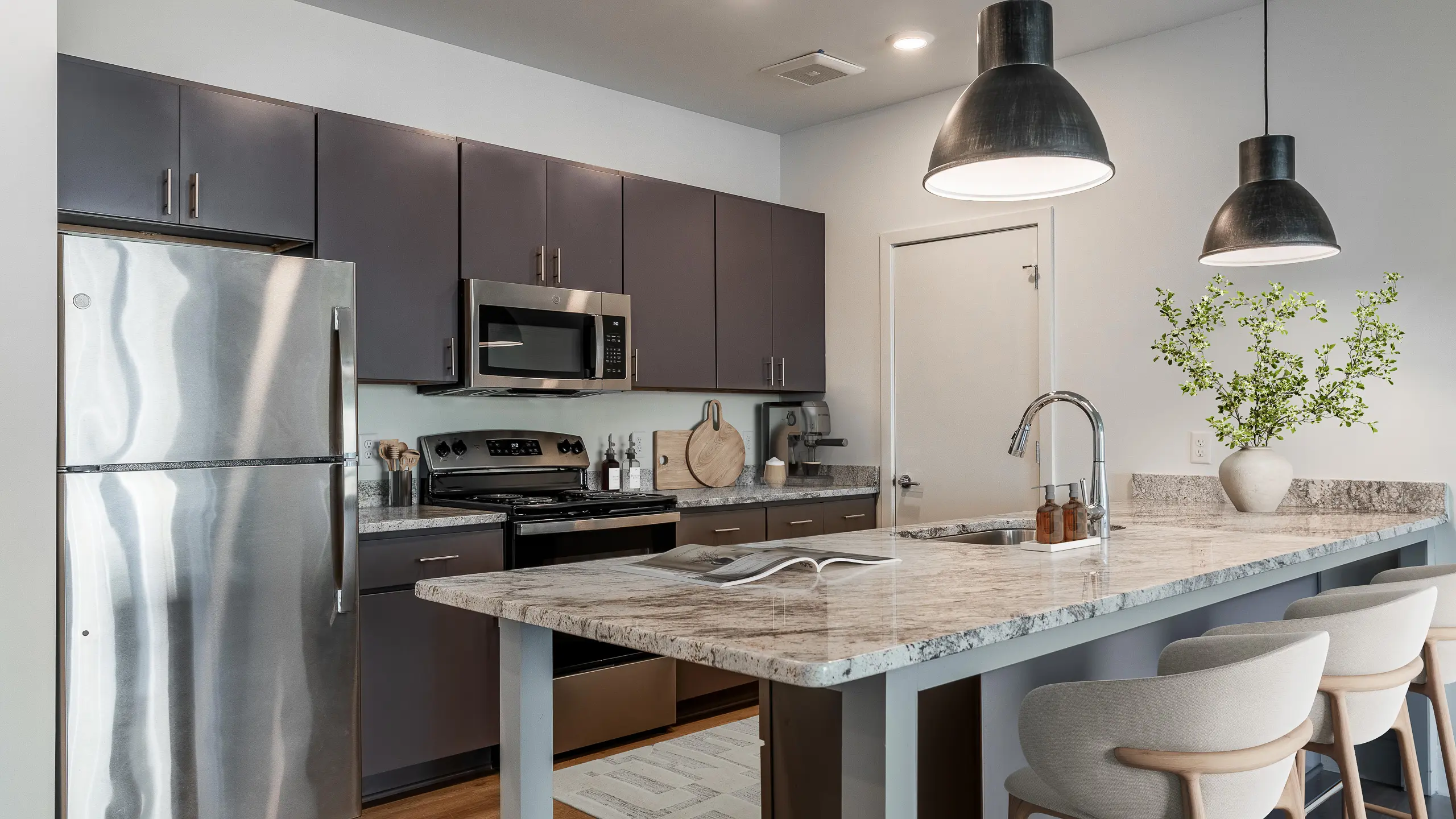 Sleek modern kitchen with stainless steel appliances, elegant granite countertops, and stylish pendant lighting.