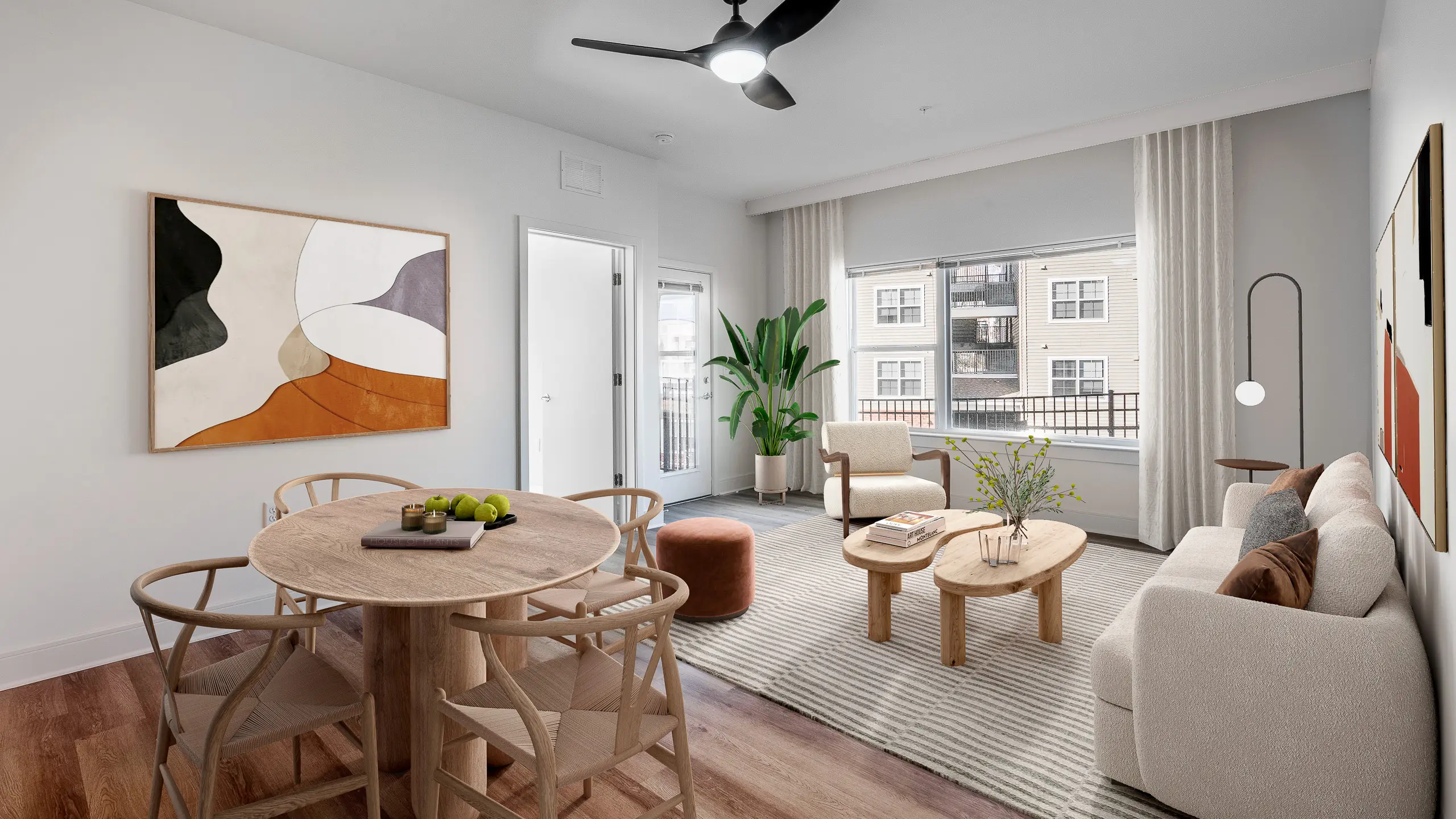 Contemporary living room with elegant decor, featuring a cozy sofa, modern dining set, and large windows offering abundant natural light.