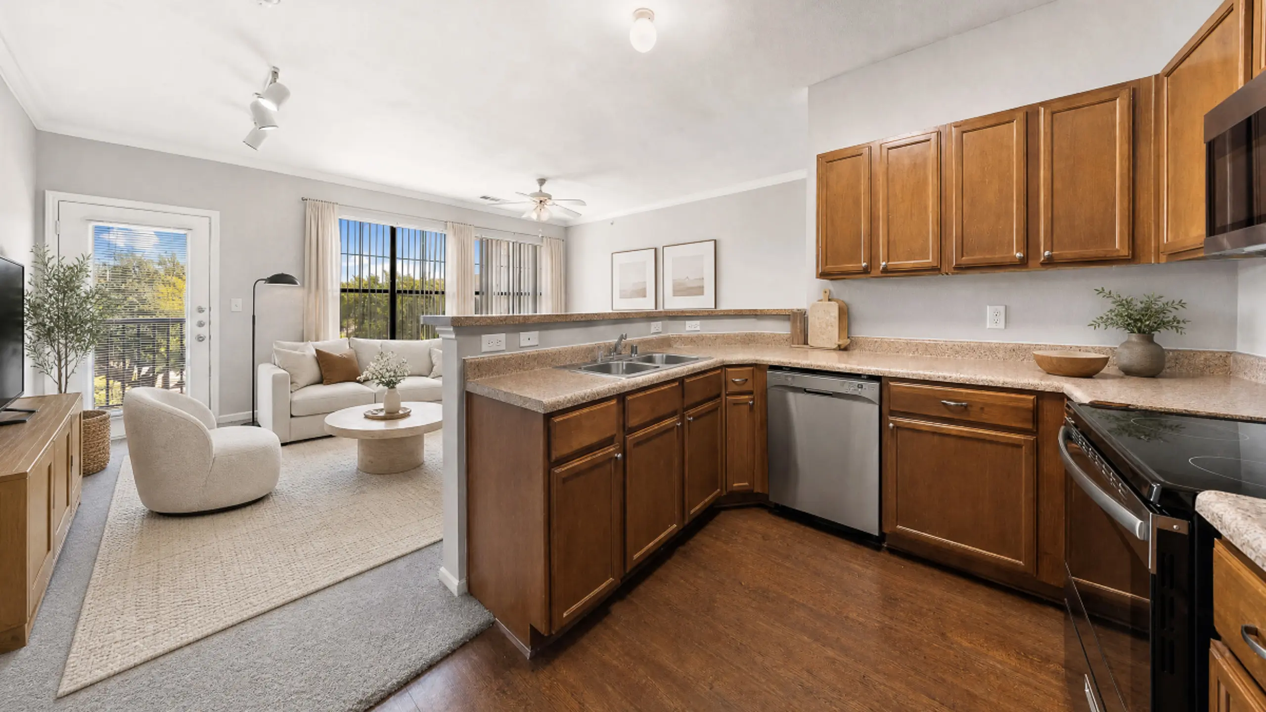 Bright and inviting open-concept living space with modern kitchen, cozy seating area, and large windows offering scenic views.