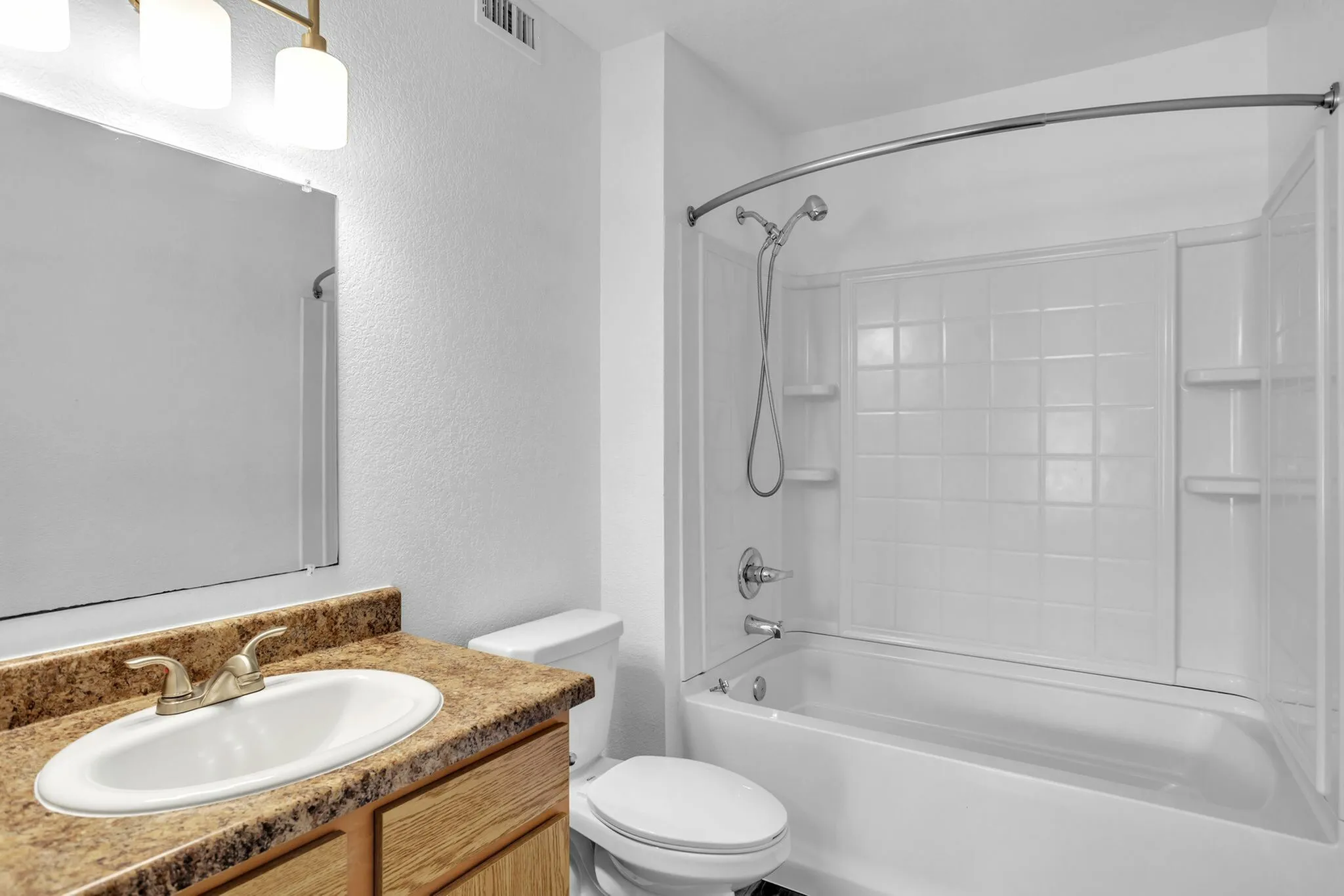 Modern bathroom design with a spacious white bathtub, elegant sink with contemporary countertop, and large mirror.