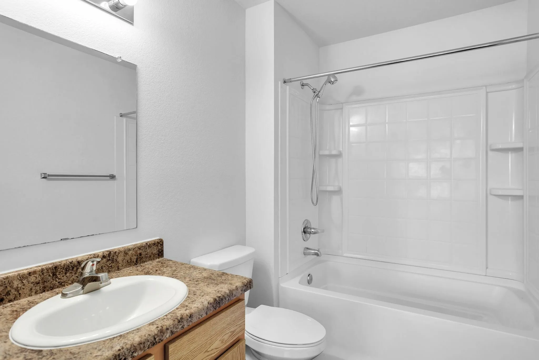 Modern bathroom featuring sleek countertop, elegant sink, and a pristine bathtub with integrated shower.