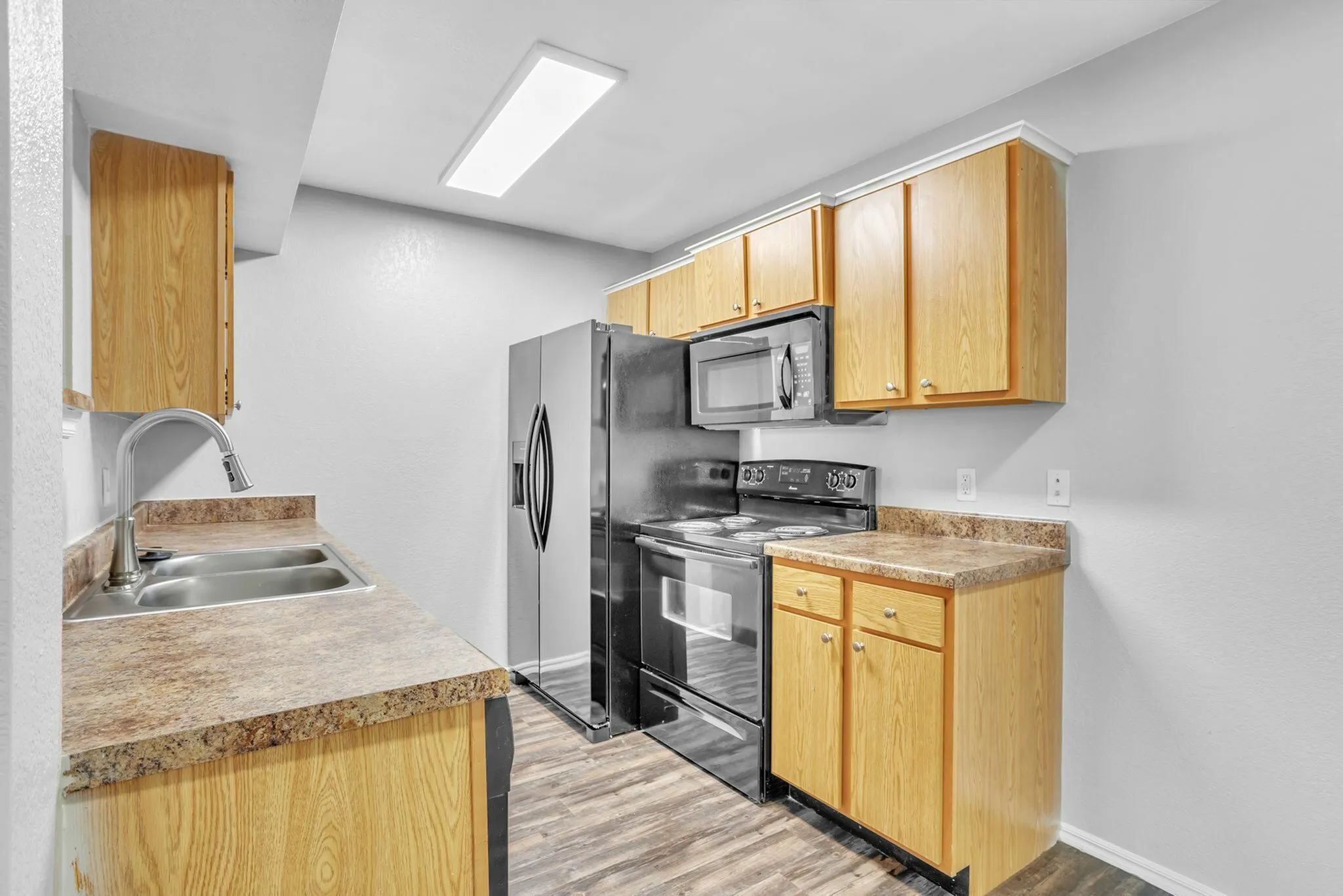 Modern kitchen with sleek appliances, elegant oak cabinetry, and contemporary countertops.