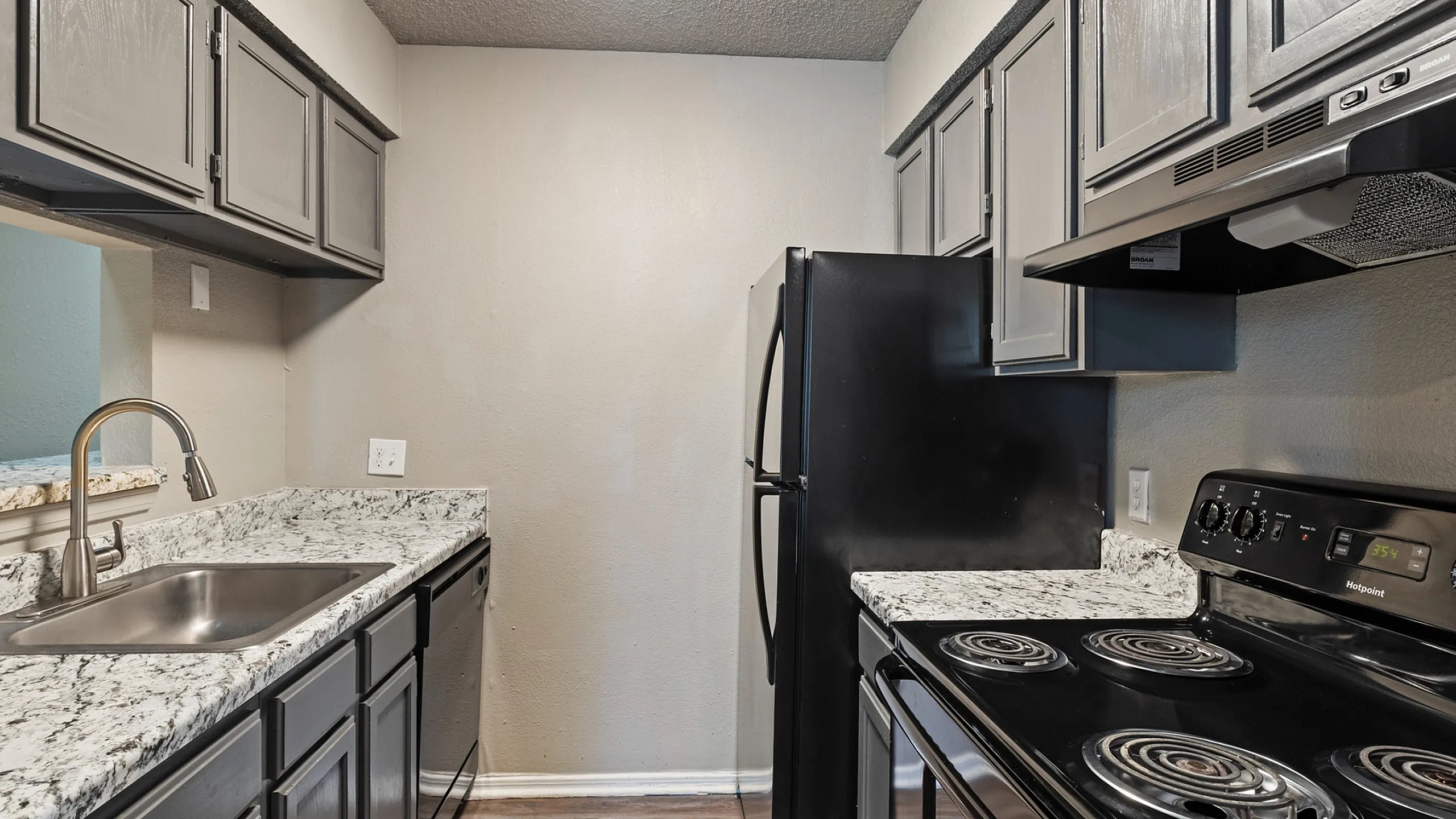 Chic kitchen with sleek black appliances, modern cabinetry, and elegant granite countertops, perfect for culinary enthusiasts.