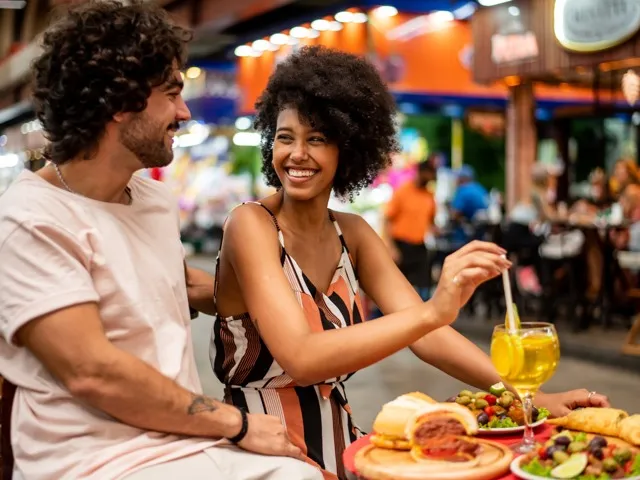 two people sitting at a table eating food