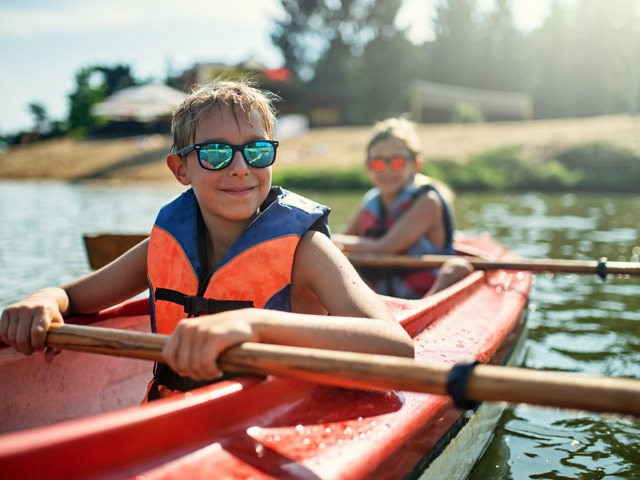 Two children on a red kayak