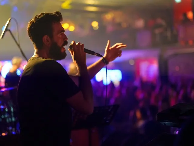 man singing on stage modera argyle apartment homes for rent