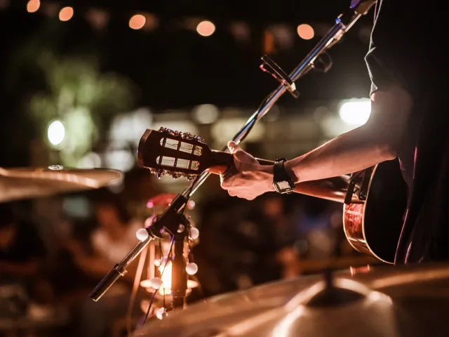 man performing live music on stage modera mckinney ridge apartment homes for rent in tx