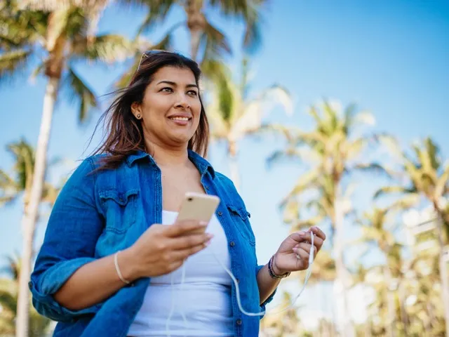 woman holding phone in hand outside modera academical village apartment homes for rent in davie fl