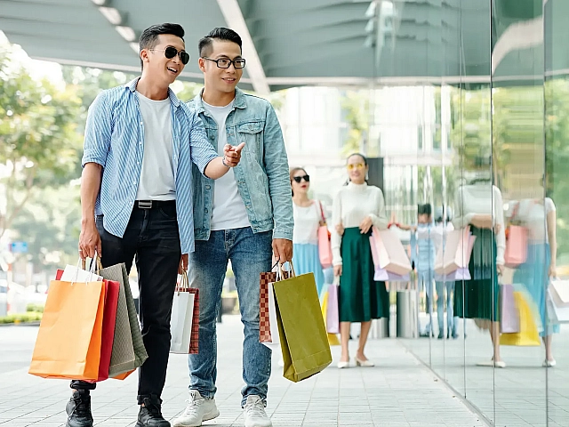two men with shopping bags pointing at store entrance modera aventura miami fl