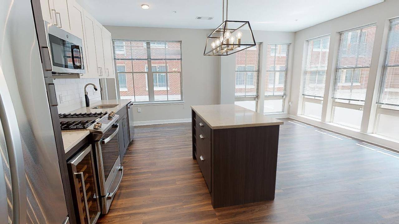 Kitchen island and upgraded bathroom features with large windows around entire living area