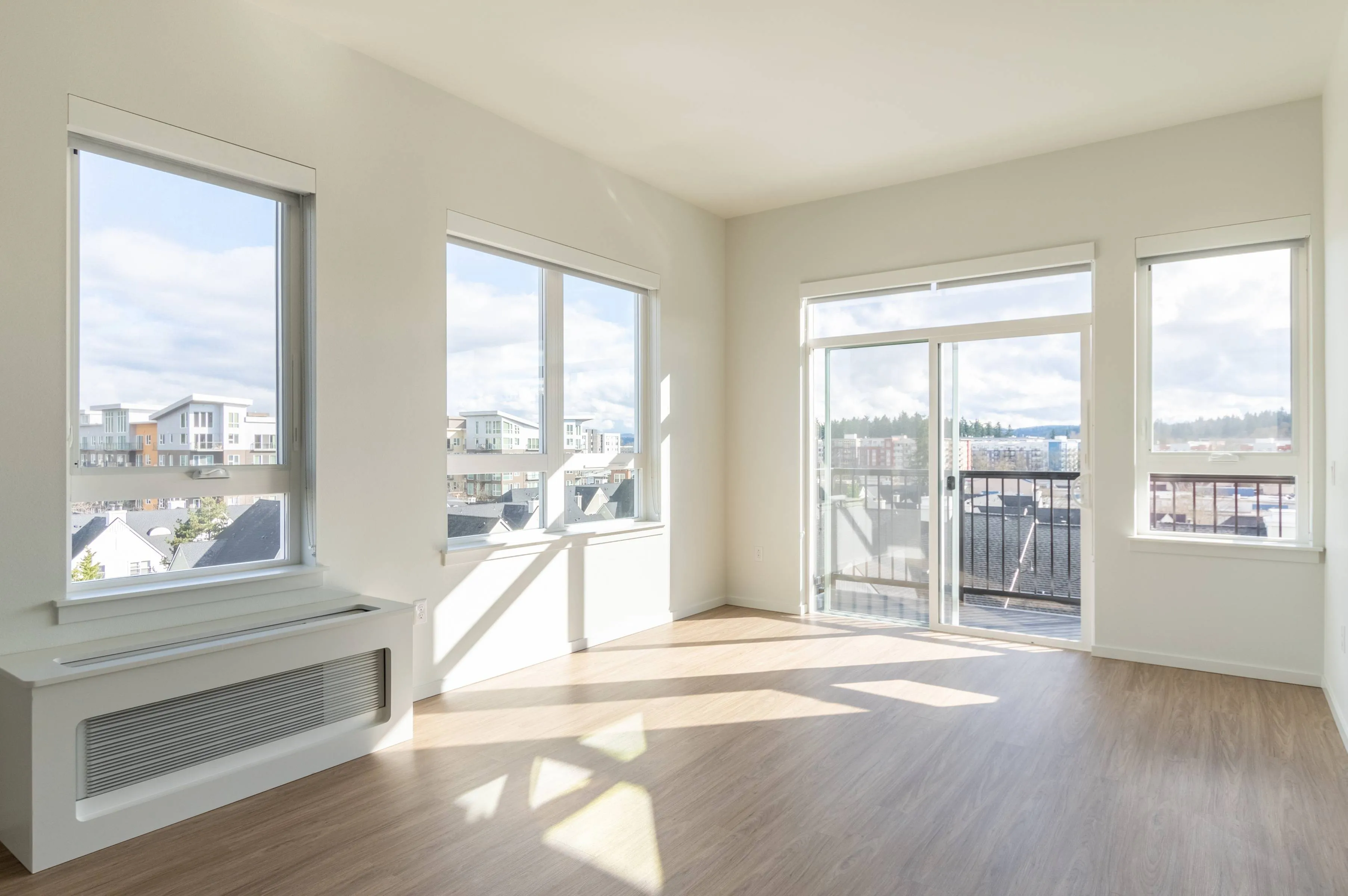 Brightly lit living room with balcony and multiple windows