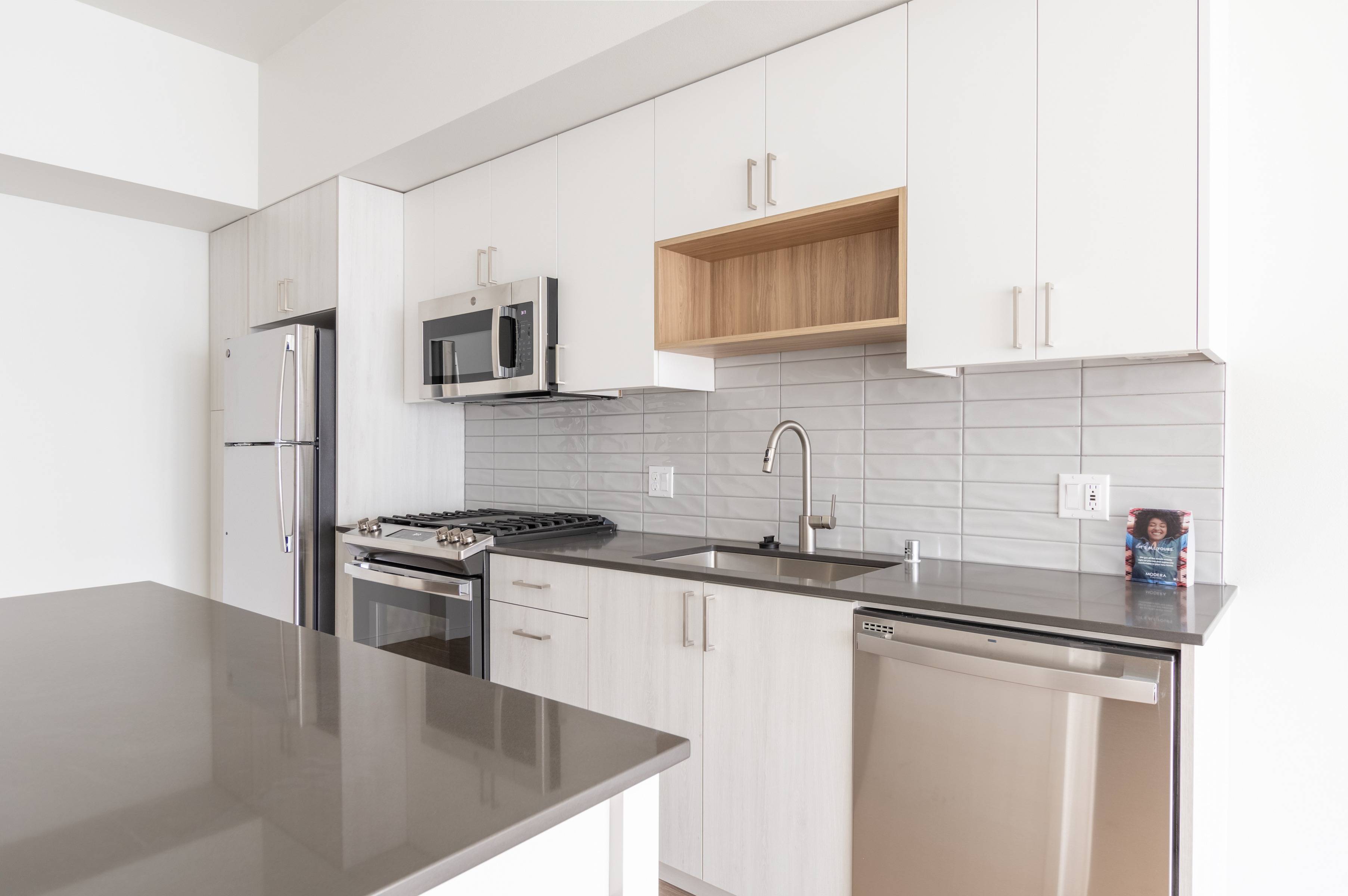 Lighter kitchen finishes with white washed cabinets and gray countertops