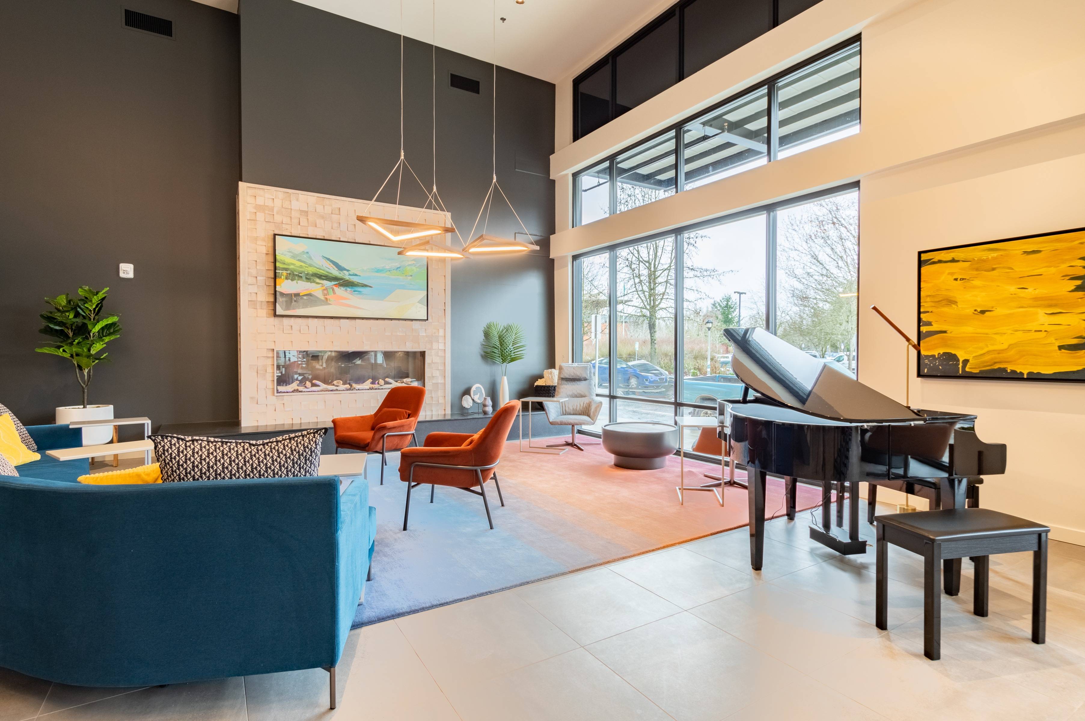 Image of piano in lobby with fireplace and large windows