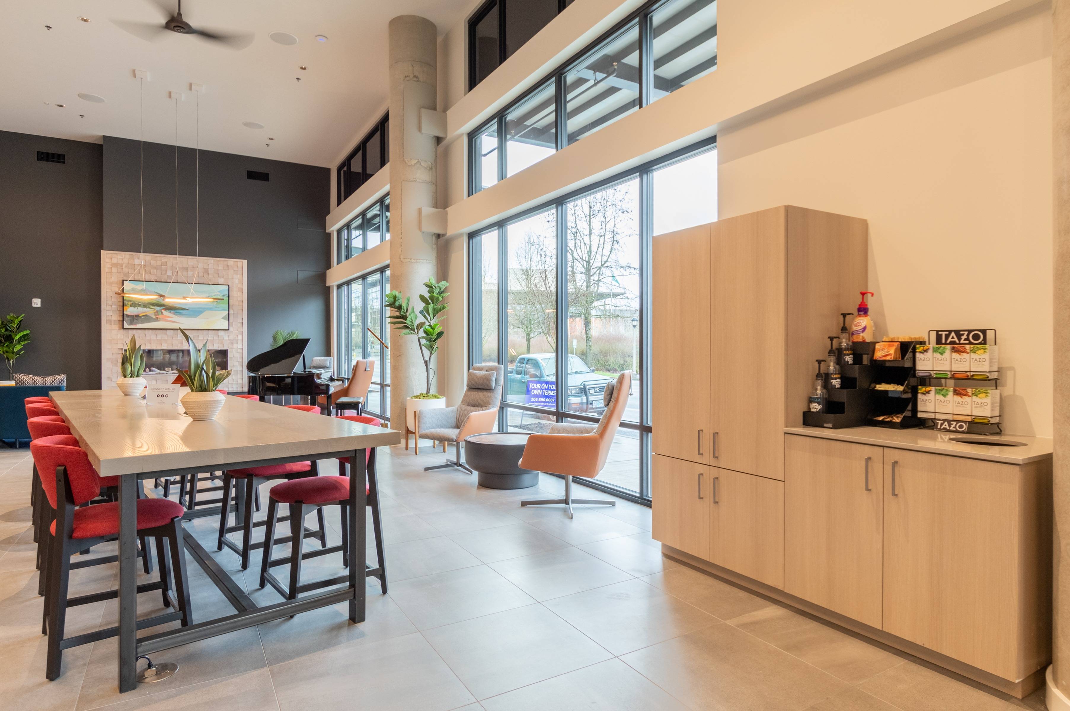 Coffee bar in lobby next to work-from-home space, piano and fireplace