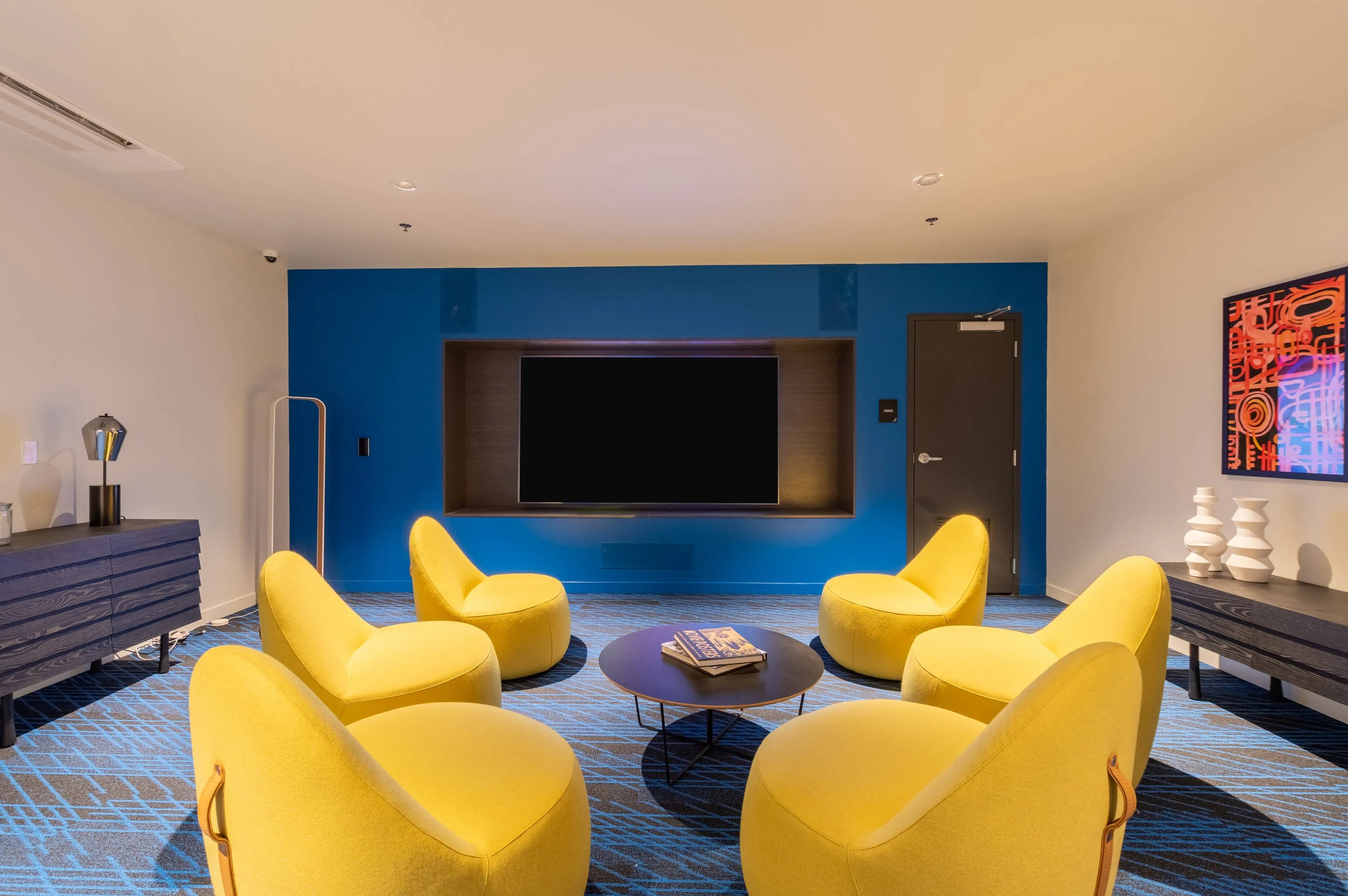 Karaoke and movie room features bright yellow chairs and a large TV screen